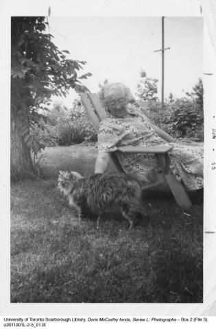 Jennie McCarthy seated in lawn chair petting cat