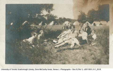 Group of girls sitting in grass at camp