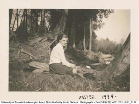 Doris McCarthy sitting on the grass in the woods
