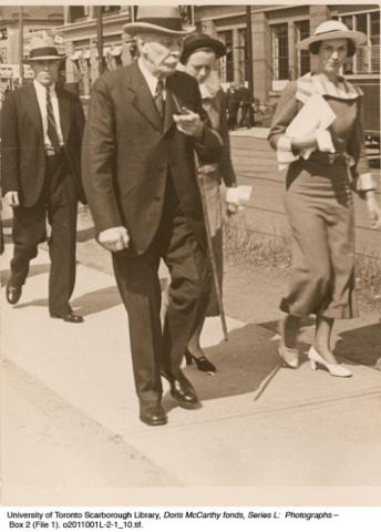 Two men and two women walking down sidewalk